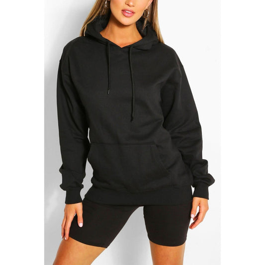  "Woman wearing an oversized black pullover hoodie with a drawstring hood and front pocket."