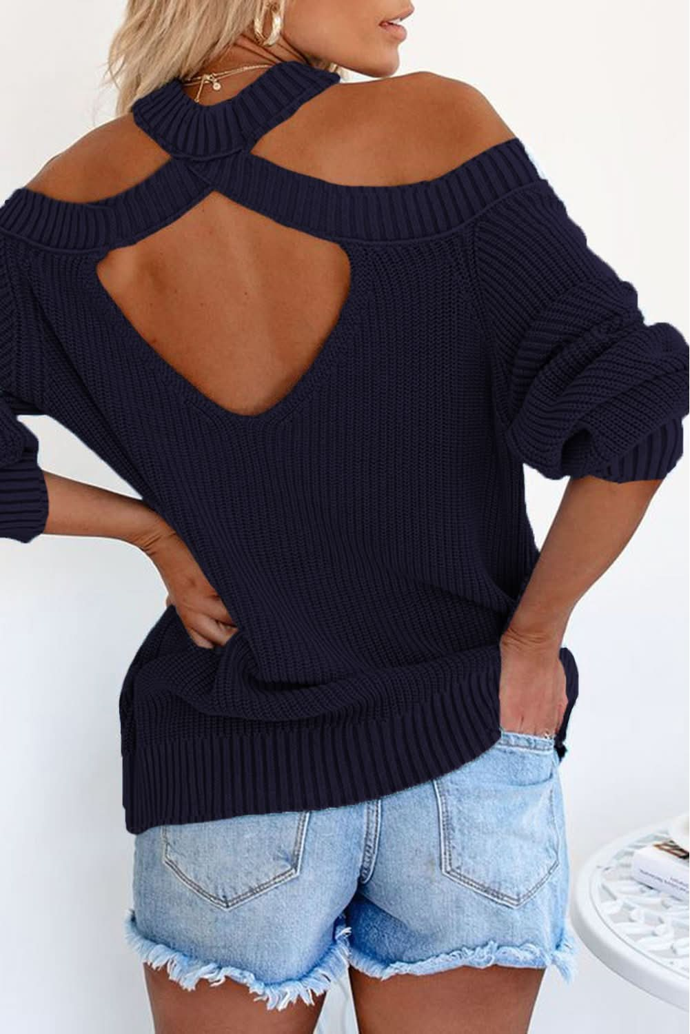 "Black cold shoulder sweater with a stylish back cutout, paired with denim shorts"